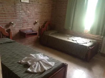 a room with two beds with towels on them at El Mirador de Nono in Nono