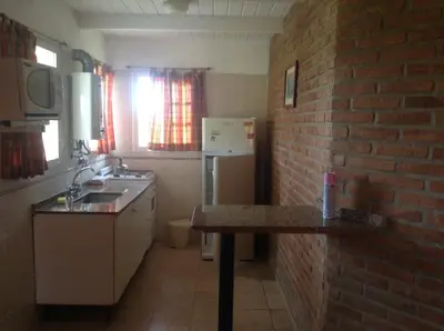 a kitchen with a sink and a brick wall at El Mirador de Nono in Nono