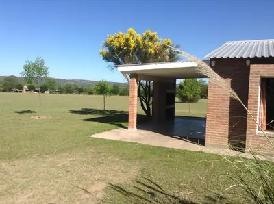 a brick building with a tree in a field at El Mirador de Nono in Nono