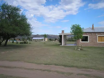 a house with a yard next to a building at El Mirador de Nono in Nono