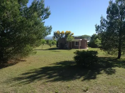 a house in the middle of a field with trees at El Mirador de Nono in Nono