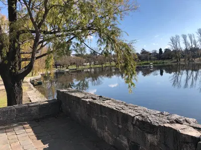 a stone retaining wall next to a lake at URBANO TAJAMAR in Alta Gracia