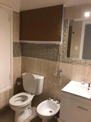 a bathroom with a white toilet and a sink at URBANO TAJAMAR in Alta Gracia