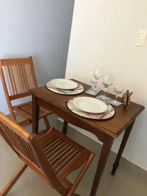 a wooden table with two plates and wine glasses at URBANO TAJAMAR in Alta Gracia