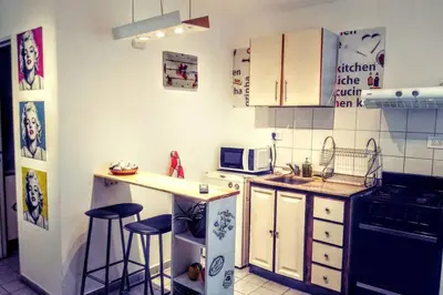 a small kitchen with a counter and stools in it at Nuevocentro Modern in Cordoba