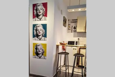 a kitchen with two bar stools and posters on the wall at Nuevocentro Modern in Cordoba