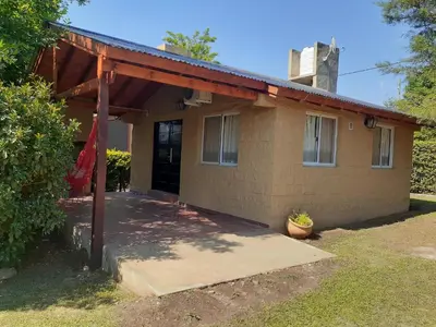 a house with a porch and a garage at Cabañas Ecos del Valle in Los Reartes