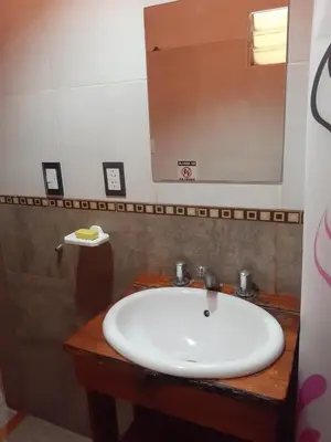a bathroom with a white sink and a mirror at Cabañas Ecos del Valle in Los Reartes