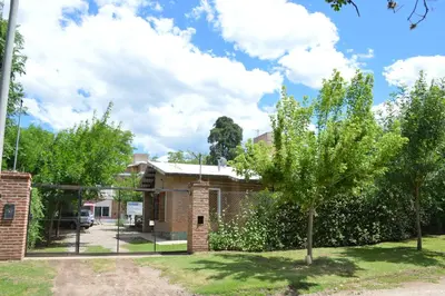a brick house with a tree in the yard at Complejo Belu in Santa Rosa de Calamuchita