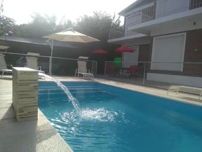 a pool with a water fountain in a building at Complejo Belu in Santa Rosa de Calamuchita