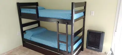 two bunk beds in a room with a fan at Complejo Belu in Santa Rosa de Calamuchita