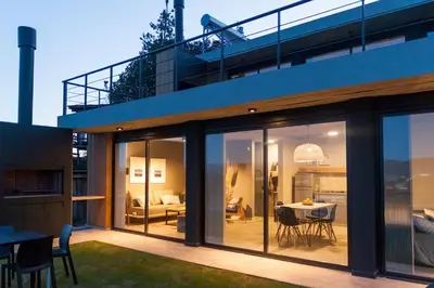 a house with large glass doors and a dining area at LUNALBA in Potrero de Garay