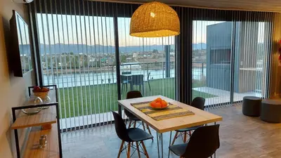 a dining room with a table and chairs and a large window at LUNALBA in Potrero de Garay