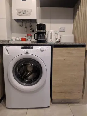 a washing machine in a kitchen next to a counter at Departamento 2 dormitorios Nueva Cordoba in Cordoba