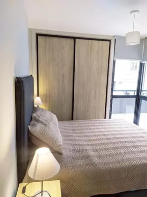 a bedroom with a bed and two lamps on a table at Departamento 2 dormitorios Nueva Cordoba in Cordoba