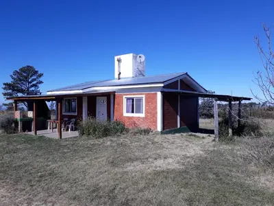 a small house with a chimney on top of a field at Alas Mágicas in Villa Yacanto