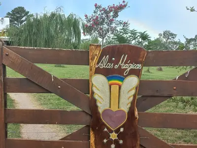 a wooden sign on a fence with a heart at Alas Mágicas in Villa Yacanto