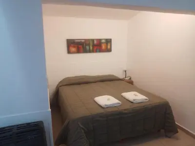 a bedroom with a bed with two towels on it at Teilen in Villa General Belgrano