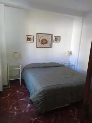 a bedroom with a bed and two pictures on the wall at Teilen in Villa General Belgrano