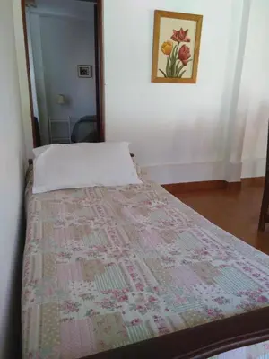 a bedroom with a bed with a quilt on it at Teilen in Villa General Belgrano