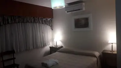 a bedroom with a bed and two lights on two tables at Teilen in Villa General Belgrano