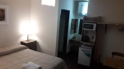 a hotel room with a bed and a desk with a microwave at Teilen in Villa General Belgrano