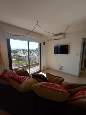 a living room with a couch and a large window at Alto Tucumán in Cordoba