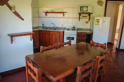 a kitchen with a wooden table and a refrigerator at La Morada in Merlo