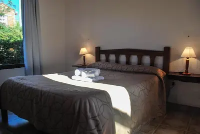 a bedroom with a bed with two lamps and a window at La Morada in Merlo