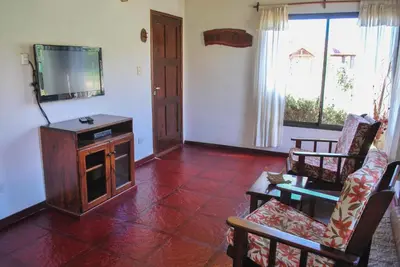 a living room with a tv and a couch and chairs at La Morada in Merlo