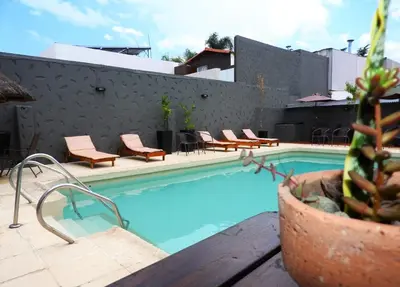 a swimming pool with chairs and a cactus next to a building at Lion D`Or in Villa Carlos Paz