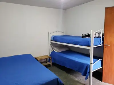 a bedroom with two bunk beds and blue sheets at La casona in Merlo