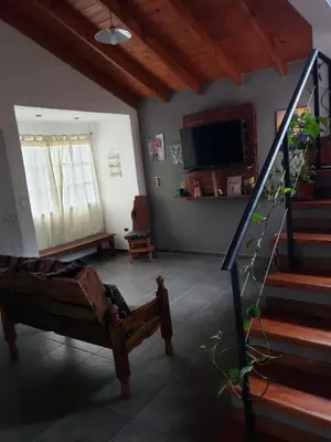 a living room with a couch and a tv and stairs at La casona in Merlo