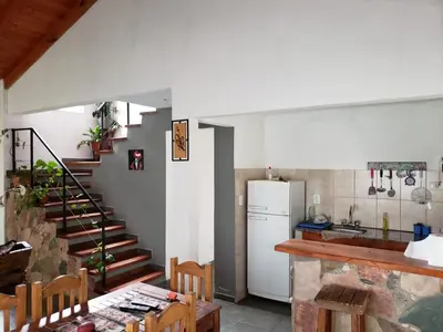 a kitchen with a staircase and a refrigerator and a table at La casona in Merlo