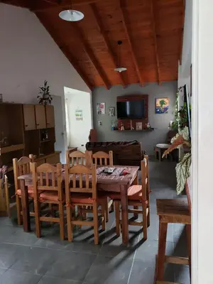 a dining room with a wooden table and chairs at La casona in Merlo
