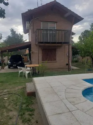 a house with a balcony and a table and a pool at La casona in Merlo