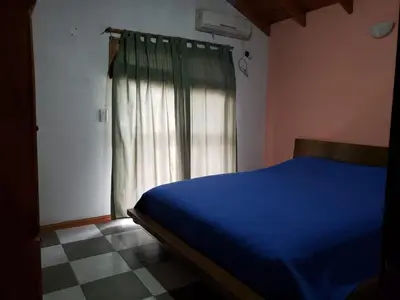 a bedroom with a blue bed and a window at La casona in Merlo