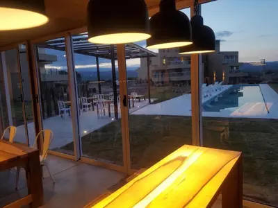 a dining room with a table and a large window at Apart Carlos Paz Golf Country Club in Villa Carlos Paz
