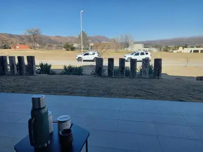 a table with a drink on it next to a parking lot at Apart Carlos Paz Golf Country Club in Villa Carlos Paz