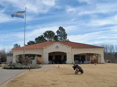 a large building with a flag in front of it at Apart Carlos Paz Golf Country Club in Villa Carlos Paz