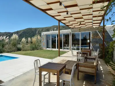 a patio with tables and chairs next to a pool at Apart Carlos Paz Golf Country Club in Villa Carlos Paz