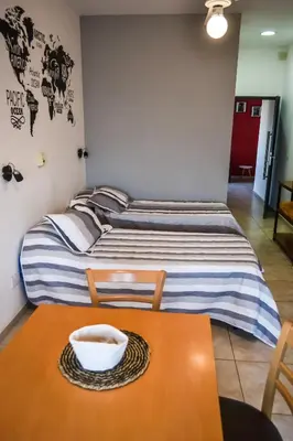 a room with two beds and a table with a bowl on it at Dpto con Balcón- Rafael Nuñez - Cerro de las Rosas in Cordoba