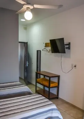 a room with two beds and a table and a tv at Dpto con Balcón- Rafael Nuñez - Cerro de las Rosas in Cordoba