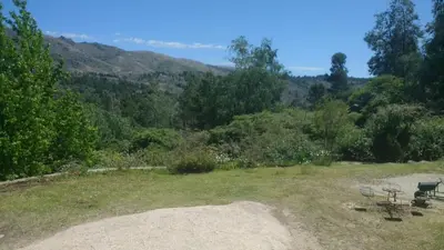 a park bench sitting on top of a grass field at Casona Familiar en La Cumbrecita in La Cumbrecita