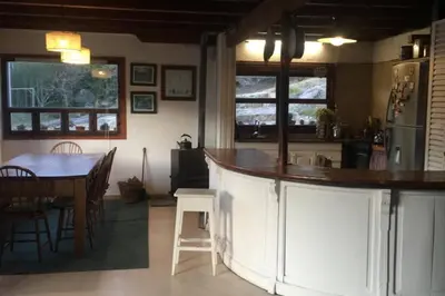 a kitchen and dining room with a counter and a table at Casona Familiar en La Cumbrecita in La Cumbrecita
