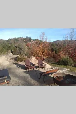 two picnic tables and chairs sitting on top of a hill at Casona Familiar en La Cumbrecita in La Cumbrecita