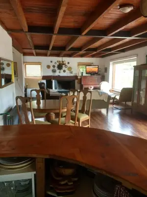 a dining room and living room with a wooden table at Casona Familiar en La Cumbrecita in La Cumbrecita