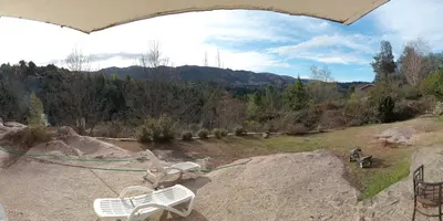 a couple of white chairs sitting on top of a rock at Casona Familiar en La Cumbrecita in La Cumbrecita
