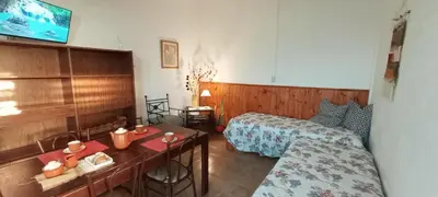 a hotel room with two beds and a desk and a table at Lago Azul in Embalse