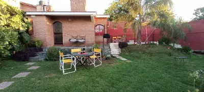 a yard with a table and chairs in front of a house at Lago Azul in Embalse